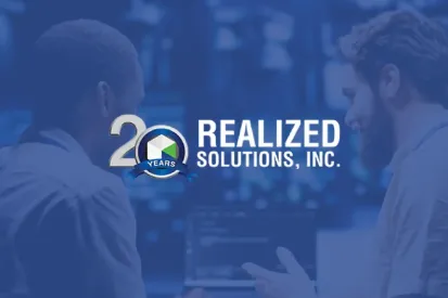 Realized Solutions technology experts collaborating on custom software development and AI-powered infrastructure in a modern office with logo